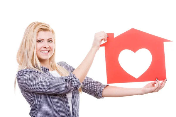 Leende flicka håller rött papper hus med hjärta form — Stockfoto