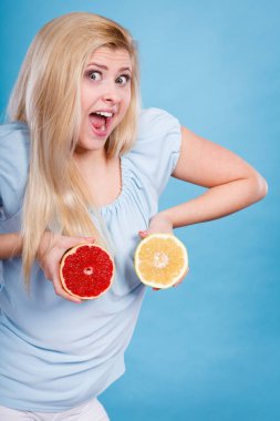 Kırmızı ve yeşil greyfurt tutan kadın