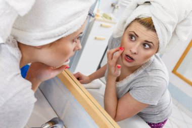 Bir kadın aynadaki yansımasına bakıyor.