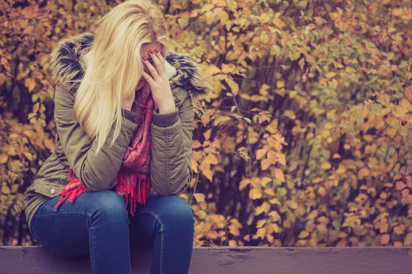 Wanita menyedihkan duduk di bangku di taman bersembunyi wajah — Stok Foto