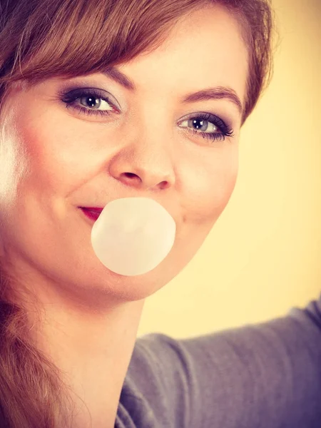 Blondes Mädchen kaut Kaugummi und macht Luftballon. — Stockfoto