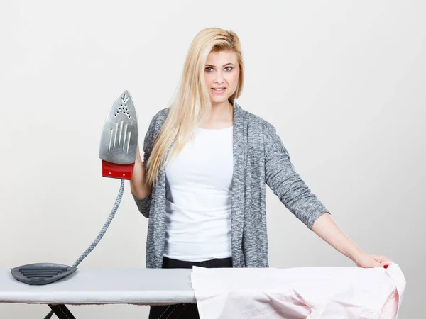 Happy woman holding iron about to do ironing — Stock Photo, Image