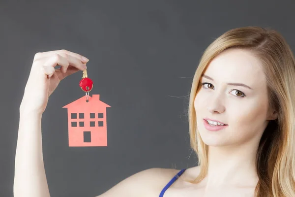 Woman holding key with house symbol — Stock Photo, Image