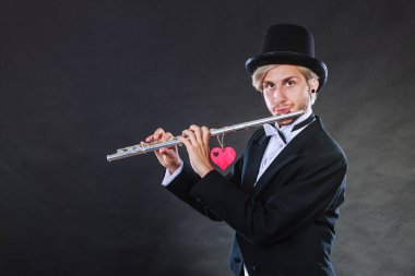 Erkek flütçü flüt ve kalp ile. Melodi seviyorum