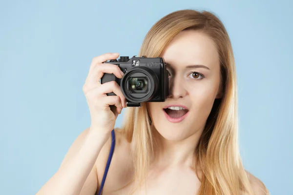 Blonde vrouw met camera op blauw — Stockfoto