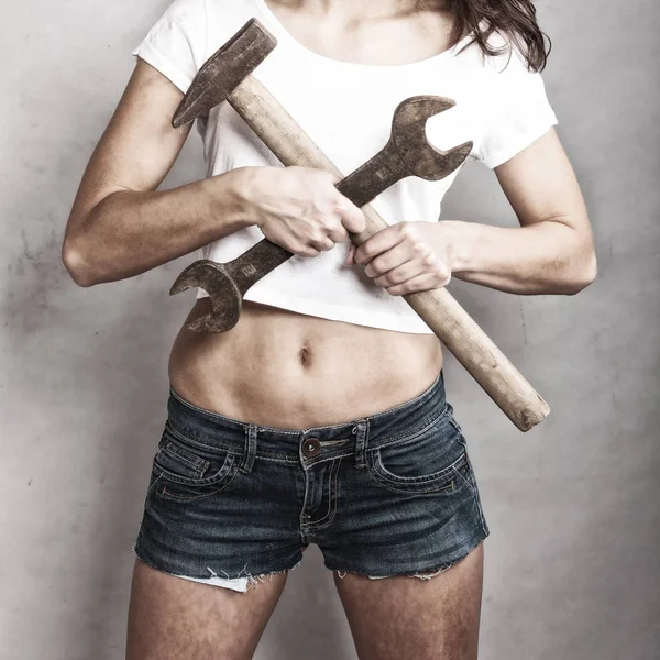 Sexy girl holding hammer and wrench spanner — Stock Photo, Image