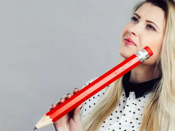 Woman confused thinking, big pencil in hand — Stock Photo, Image