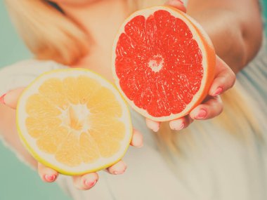 Kırmızı ve yeşil greyfurt tutan kadın