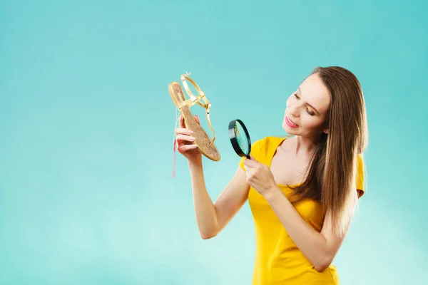 Femme choisissant des chaussures de recherche à travers la loupe — Photo