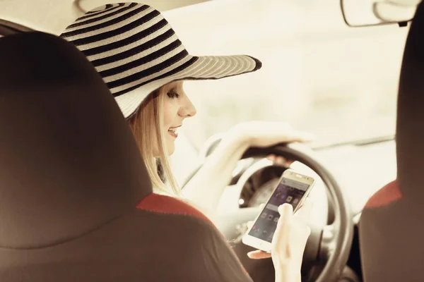 Mujer usando el teléfono mientras conduce su coche —  Fotos de Stock