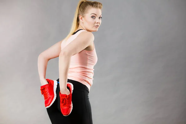 Femme heureuse présentant des chaussures de baskets de sport — Photo