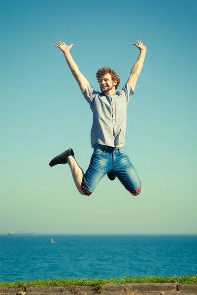 Hombre despreocupado saltando por mar océano . — Foto de Stock