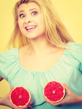 Kırmızı greyfurt meme üzerinde tutan kadın