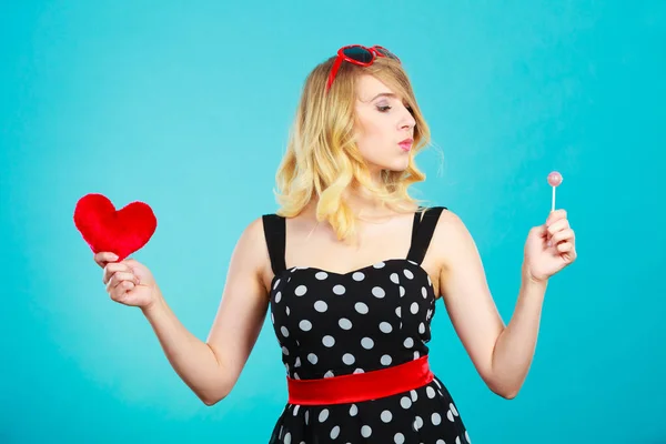 Mujer sostiene corazón rojo símbolo de amor y caramelo piruleta —  Fotos de Stock