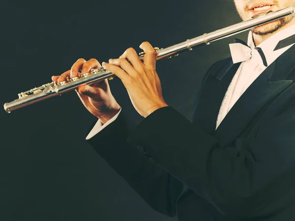 Elegant gekleed mannelijke muzikant speelt fluit — Stockfoto