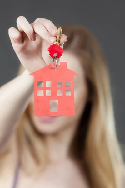 Mujer sosteniendo la llave con símbolo de la casa — Foto de Stock