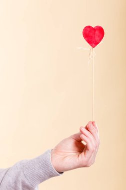 Kişi holding kalp çubuk üzerinde.