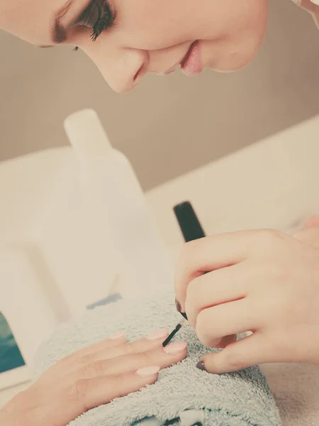 Woman in beauty salon getting manicure done.