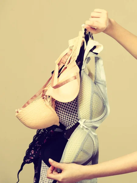 Female hand with many bras to wear — Stock Photo, Image