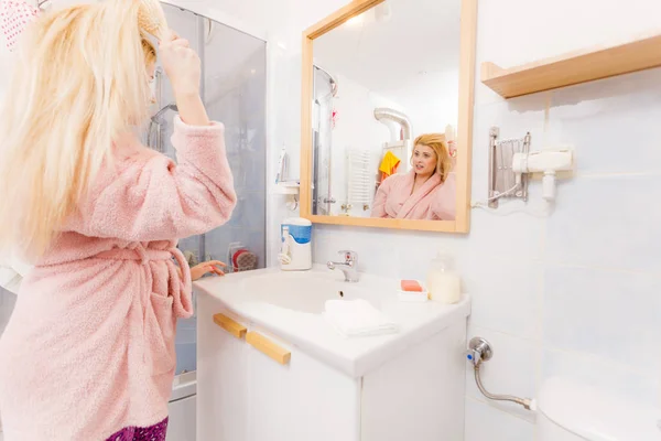 Vrouw haar haren borstelen badjas dragen — Stockfoto