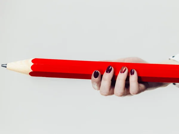 Ręka trzyma duży czerwony ołówek — Zdjęcie stockowe