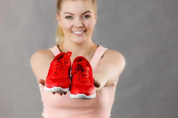 Mujer feliz presentando zapatillas deportivas zapatillas —  Fotos de Stock