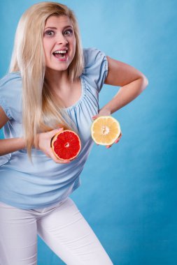 Kırmızı ve yeşil greyfurt tutan kadın