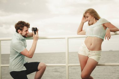 Aşık genç bir çift deniz iskelede fotoğraf çekmek.