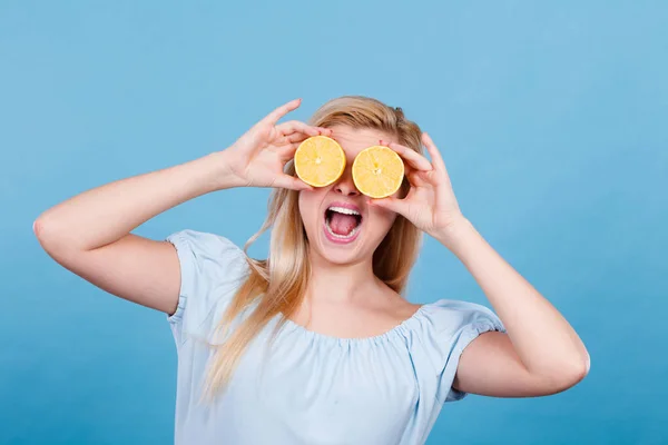 Девушка закрывает глаза лимонными цитрусовыми фруктами — стоковое фото