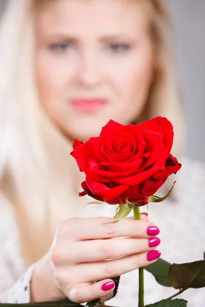 Vrouw met rode roos in de hand — Stockfoto