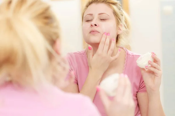 Woman applying face cream with her finger — Stock Photo, Image