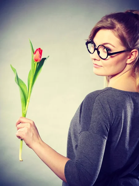 Blonde woman with single tulip.