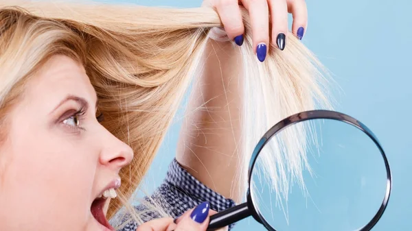 Frau betrachtet Haare durch Lupe — Stockfoto