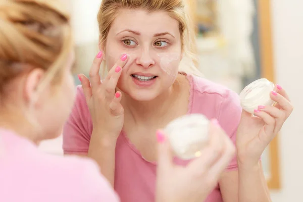 Vrouw toepassen Gezichtscrème met haar vinger — Stockfoto