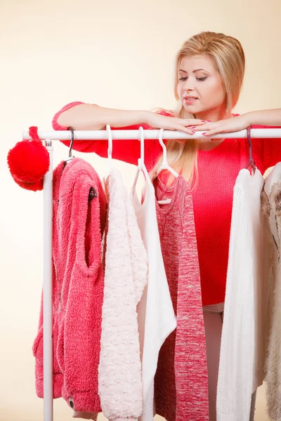 Woman standing in wardrobe picking winter outfit