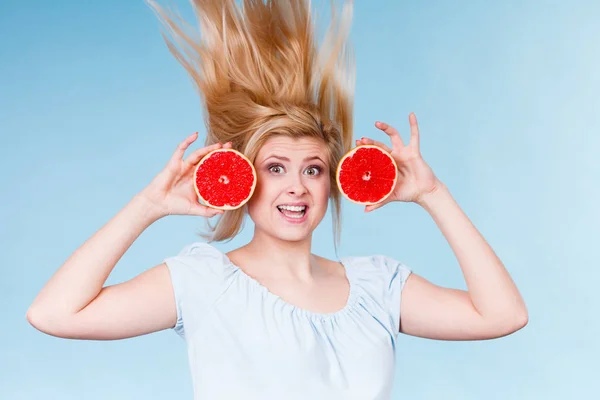 狂気の風に吹かれた髪を持つ赤いグレープ フルーツを保持している女性 — ストック写真