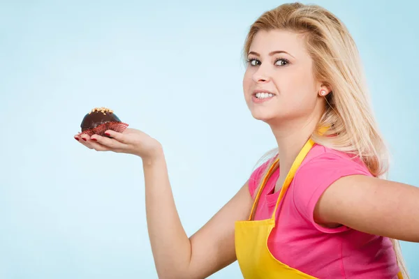 Женщина держит шоколадный кекс на пороге укуса — стоковое фото