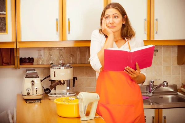 Домохозяйка с поваренной книгой на кухне . — стоковое фото