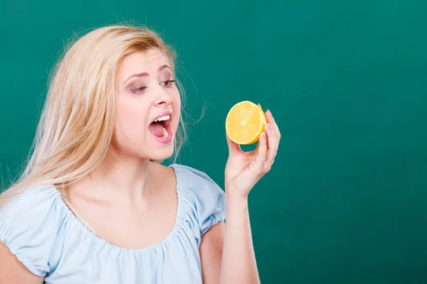 Mulher com boca aberta segurando limão — Fotografia de Stock