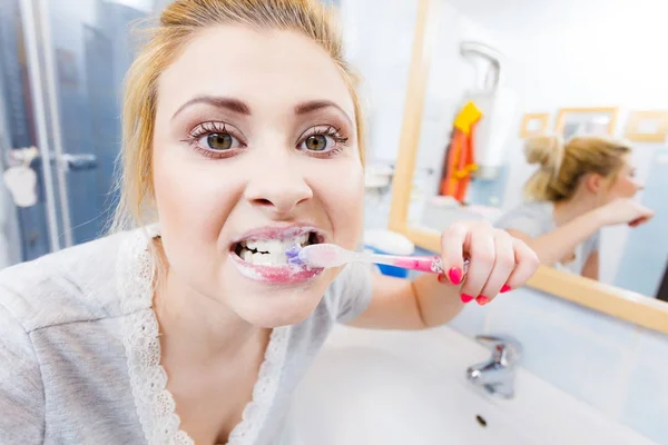 Woman brushing cleaning teeth in bathroom