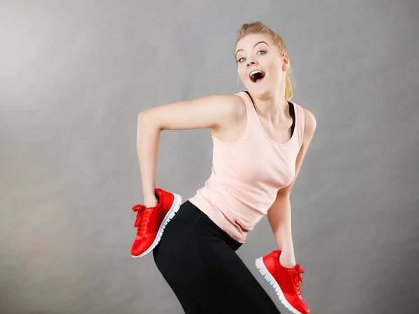 Happy woman presenting sportswear trainers shoes — Stock Photo, Image