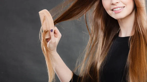 Довгошерста дівчина розчісує волосся . — стокове фото