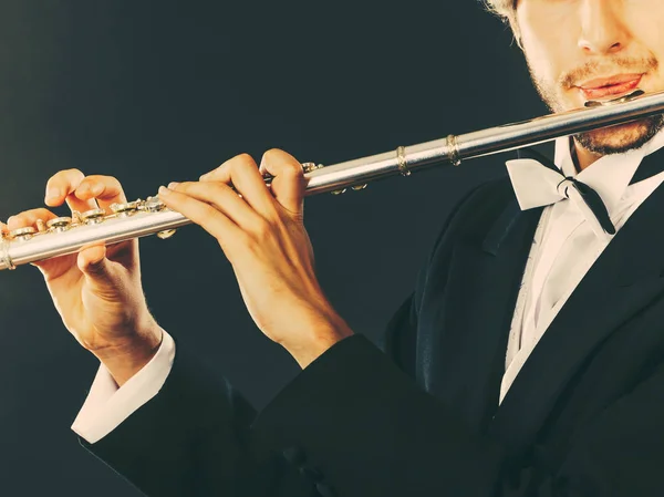 Elegantemente vestido músico masculino tocando flauta — Fotografia de Stock