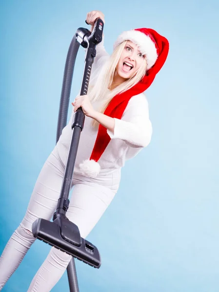Meisje in helper kerstmuts met een stofzuiger — Stockfoto