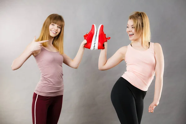 Duas mulheres apresentando sapatos treinadores sportswear — Fotografia de Stock