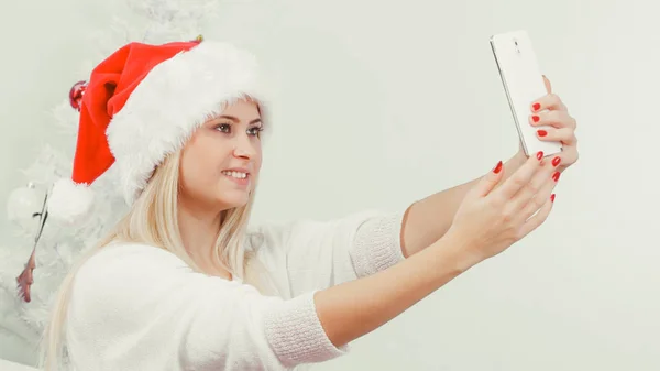 Woman in santa hat taking selfie — Stock Photo, Image