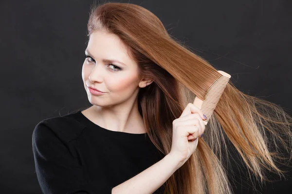 Long haired girl combing her beauty hair.