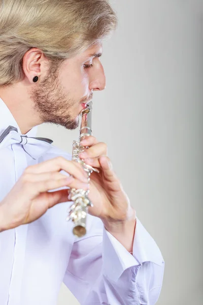 Мужской флейтист играет на флейте — стоковое фото