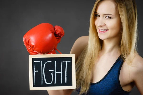 Žena nosí Boxerské rukavice drží boj znamení — Stock fotografie