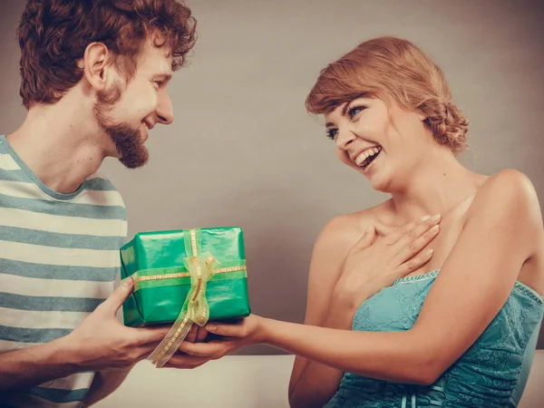 Egy fiatal férfi ajándékdobozt ad a nőnek. — Stock Fotó